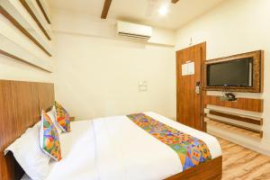 1 dormitorio con 1 cama y TV de pantalla plana en FabHotel Arastu en Hyderabad