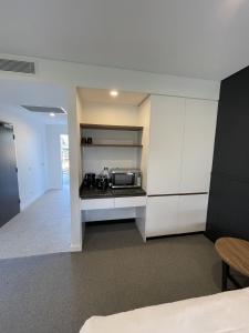 a kitchen with white cabinets and a microwave at Harden Country Club Motel in Harden