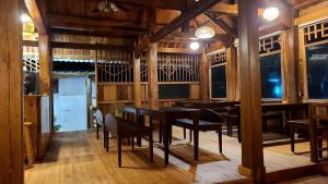 una sala da pranzo con pareti e tavoli in legno e sedie di nhà gỗ homestay nguyên văn a Hưng Lương