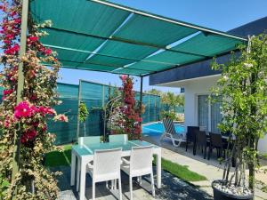 een patio met een blauwe tafel en stoelen en bloemen bij Villa tiele in Fethiye