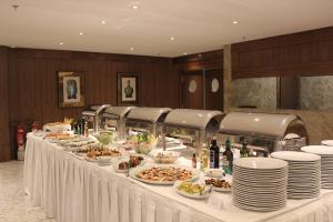 a buffet table with plates and food on it at Windsor Marapendi Hotel in Rio de Janeiro