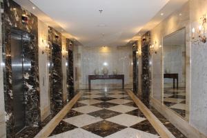 a lobby with a marble floor and gold walls at Windsor Marapendi Hotel in Rio de Janeiro