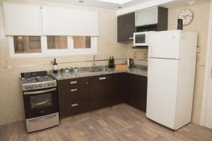 cocina con nevera blanca y fogones en Mdz Apartments en Mendoza