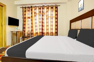 a bedroom with a large bed and a television at OYO Hotel Basera in Shimla