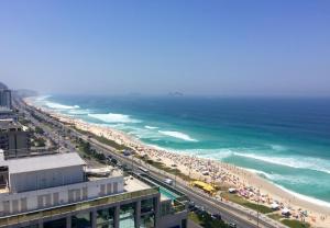 a beach with a lot of people and the ocean at Windsor Marapendi Hotel in Rio de Janeiro