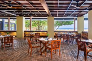 un restaurante con mesas y sillas y vistas al océano en Heritance Ahungalla, en Bentota