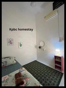 a bedroom with a bed and a sign that reads kpie homogeneity at Kpbc Homestay 3bilik in Jitra