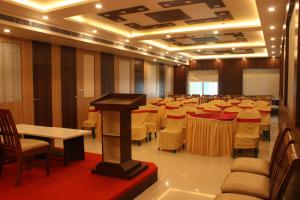 a conference room with tables and chairs and a podium at Sea Resort in Digha