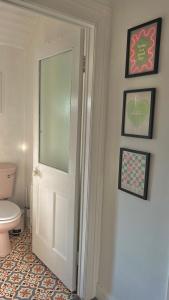 ein Badezimmer mit einer weißen Tür und einem WC in der Unterkunft Honeymoon Row in Pennyburn
