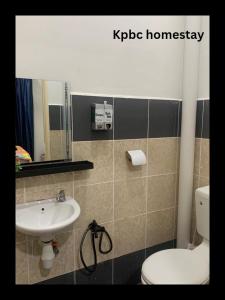 een badkamer met een wastafel, een toilet en een spiegel bij Kpbc Homestay 3bilik in Jitra