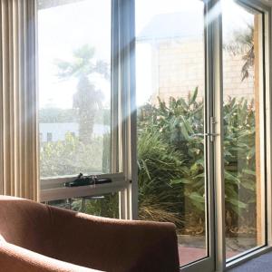 un soggiorno con divano e una grande finestra di Waves Luxury Suites a Port Campbell