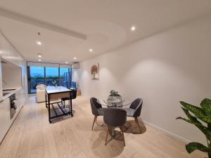 a living room with a table and a piano at Serenity 1br Flemington Balcony Pool Free Park in Melbourne