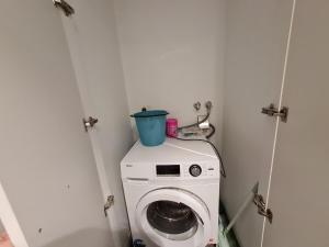 a washing machine with a bucket on top of it at Serenity 1br Flemington Balcony Pool Free Park in Melbourne