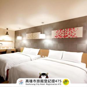um quarto com 2 camas e lençóis brancos em Kindness Hotel-Jue Ming em Kaohsiung