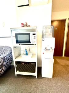 a microwave oven on a shelf in a room at GuestHouseえにし in Nishi-kujō-Toriiguchichō