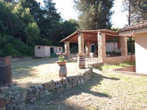 a stone wall in front of a house at Piccolo appartamento immerso nella campagna in Rosignano Marittimo