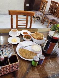 un tavolo ricoperto di piatti di cibo e pane di Hotel Marina Near IGI Airport Delhi a Nuova Delhi