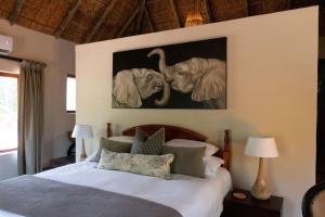 a bedroom with two elephants hanging on the wall at Mologa River Lodge in Rust de Winter