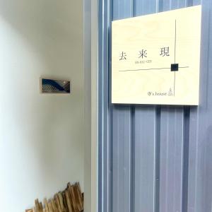 a sign hanging on a wall with writing on it at 湖北 寺の宿- GuestHouse去-来-現Ko-Rai-Gen in Nagahama