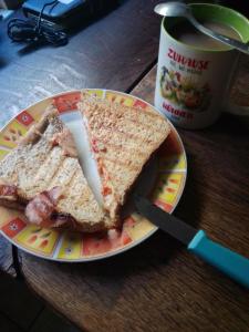 a plate with a sandwich on a table with a knife at Zum stillen Himmelbett in Niederwiesa