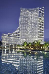 - un grand bâtiment avec une piscine en face dans l'établissement Grand Sapphire Resort & Casino, à Trikomo