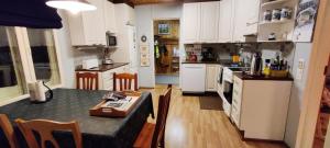 a kitchen with a table and a kitchen with white cabinets at Vacation House Kommee Kurki in Sastamala