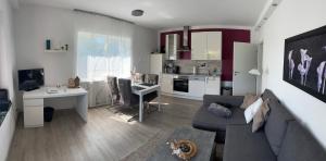 un soggiorno con un divano, un tavolo e una cucina di Ferienwohnung Schlossblick - 4 Sterne Sauna Pool Whirlpool exklusiv a Braunfels