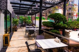 ein Restaurant mit Tischen und Stühlen auf einer Terrasse in der Unterkunft Capital Garden Hotel in Hanoi