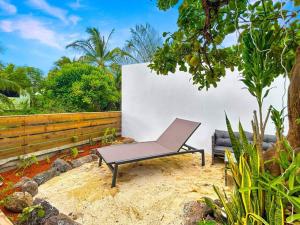 a chair and a couch sitting in a yard at Free canoës Air-Conditioning King Bed Fare Tiare in Haapiti