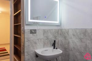 La salle de bains est pourvue d'un lavabo blanc et d'une fenêtre. dans l'établissement Departamento con vista al sunset, à Lima