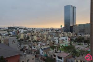 une ligne d'horizon avec des bâtiments et un grand gratte-ciel dans l'établissement Departamento con vista al sunset, à Lima