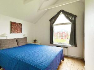 a bedroom with a blue bed and a window at 6 person holiday home in Hadsund-By Traum in Hadsund