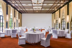 a room with white tables and chairs and large windows at Heritance Ahungalla in Bentota