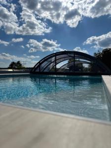 ein Schwimmbad mit einer Brücke im Hintergrund in der Unterkunft Ferienwohnung Schlossblick - 4 Sterne Sauna Pool Whirlpool privat in Braunfels
