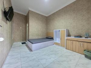 a kitchen with a couch in the corner of a room at Subali Guest House in Ponorogo