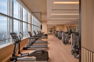 a gym with a row of treadmills and machines at Park Hyatt Changsha in Changsha