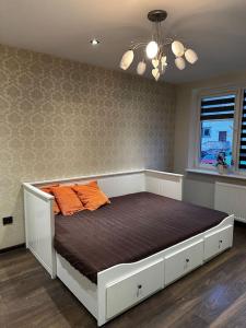 ヨニシュキスにあるDviejų miegamųjų butasのオレンジ色の枕2つが備わるベッド1台