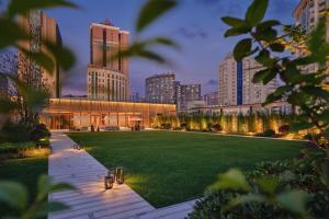 a rendering of a building with a lawn in front of a city at Park Hyatt Changsha in Changsha