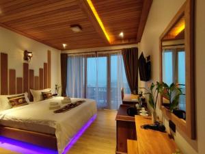 a bedroom with a large bed and a large window at Mingalar Boutique Hotel in Kawthaung