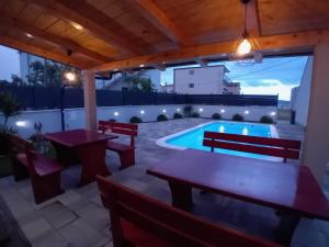 patio ze stołem i ławkami oraz basenem w obiekcie Villa Felicita w Trogirze