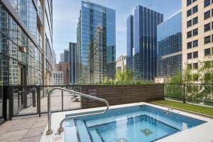 a hot tub on the roof of a building with skyscrapers at Loop 1BR w Pool Gym nr Financial District CHI-268 in Chicago