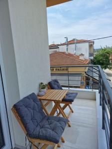 d'un balcon avec une table en bois et deux chaises. dans l'établissement Naturia Katoikia, à Vólos