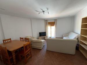 a living room with a white couch and a table at Casa amplia con terraza en La Viñuela in Viñuela