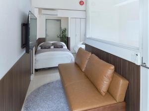 una sala de estar con un sofá y una cama en Sakura Cross Hotel Ueno Iriya, en Tokio 27 fotos más