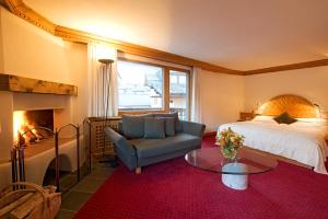 シルヴァプラーナにあるAlbana Hotel Silvaplanaのベッドルーム(ベッド1台、椅子、暖炉付)