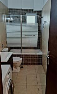 y baño con bañera, aseo y lavamanos. en Eretria Apartments FM14, en Eretria