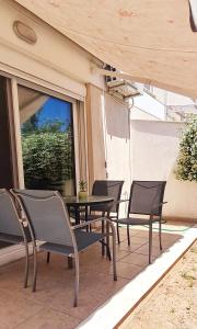 un patio con sillas, una mesa y una ventana en Eretria Apartments FM14, en Eretria