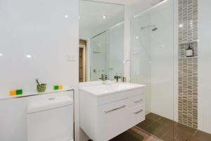 Un baño blanco con lavabo y ducha. en 10 Kanangra Crescent - Entire, en Jindabyne 23 fotos más