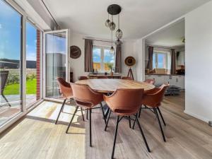 cocina y comedor con mesa de madera y sillas en Ferienhaus Ostfriesenloft, en Hage