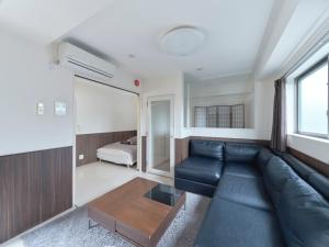 una sala de estar con un sofá y una cama en Sakura Cross Hotel Ueno Iriya, en Tokio